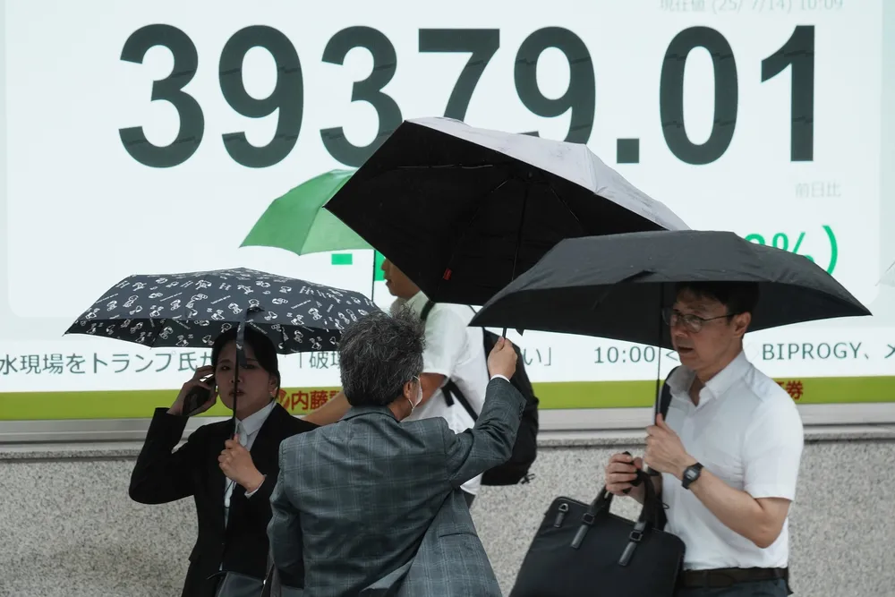 Det er en avventende stemning ved Asia-børsene mandag formiddag. Her fra en regnfull dag i Tokyo, hvor Nikkei-indeksen har beveget seg mellom en markant nedgang fra morgenen av til å vise en flat utvikling.