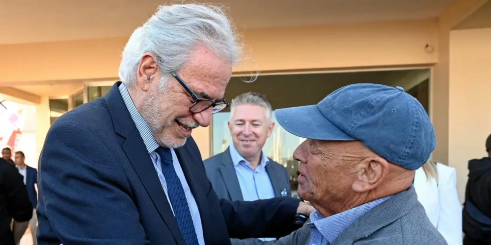 Incoming Greek shipping minister Christos Stylianidis (left) hugs Greek owner George Procopiou during the Olympic Yacht Show near Athens.