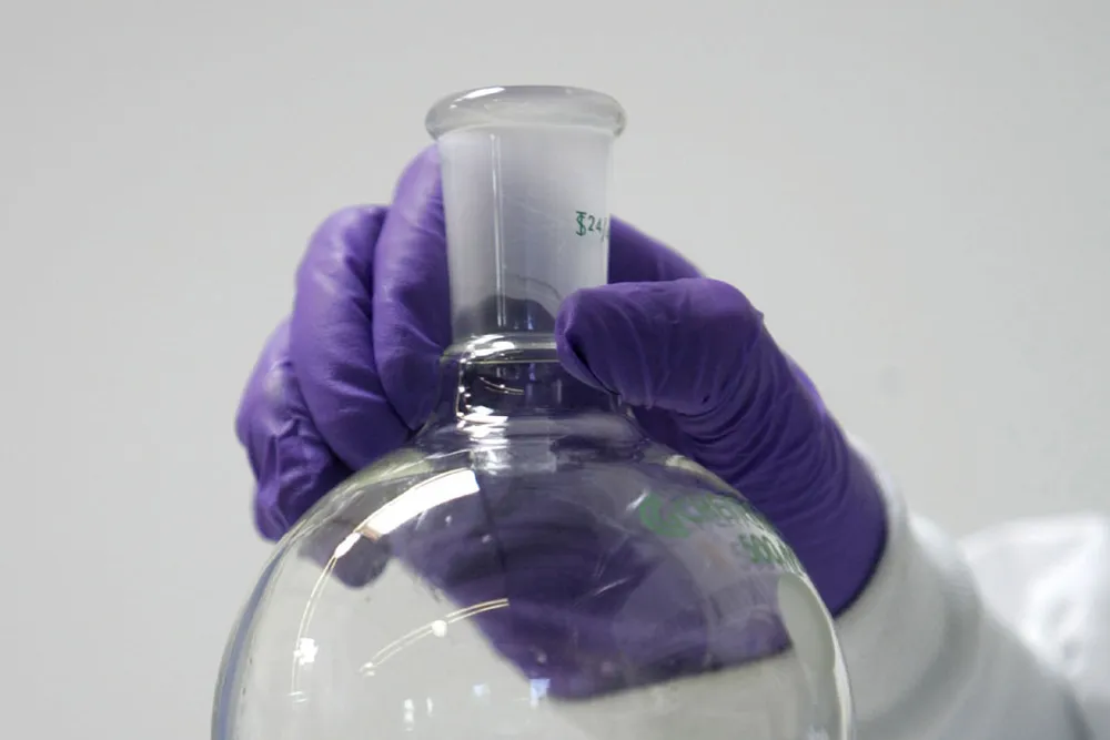 Alternative energy? a research chemist holds a sample of synthetic fuel made from algae