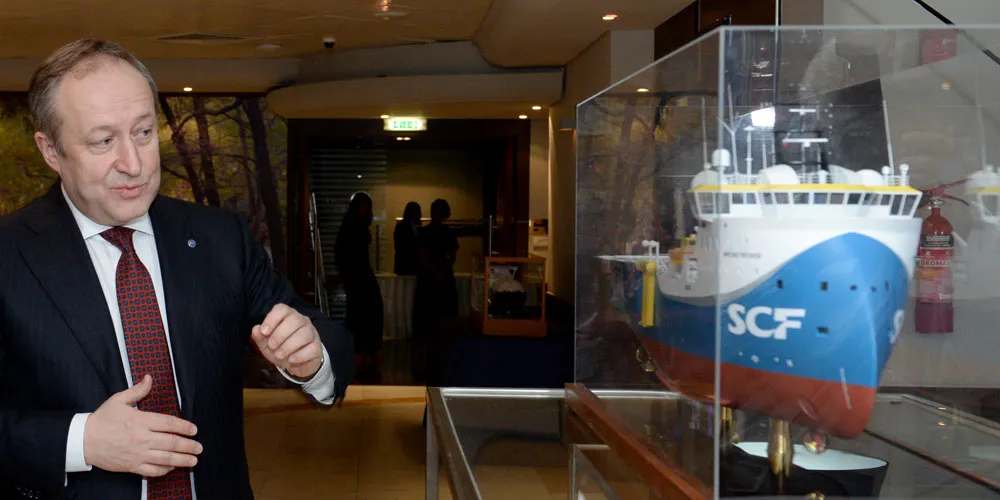 Sovcomflot president and chief executive Sergey Frank inspect a model of a ship.