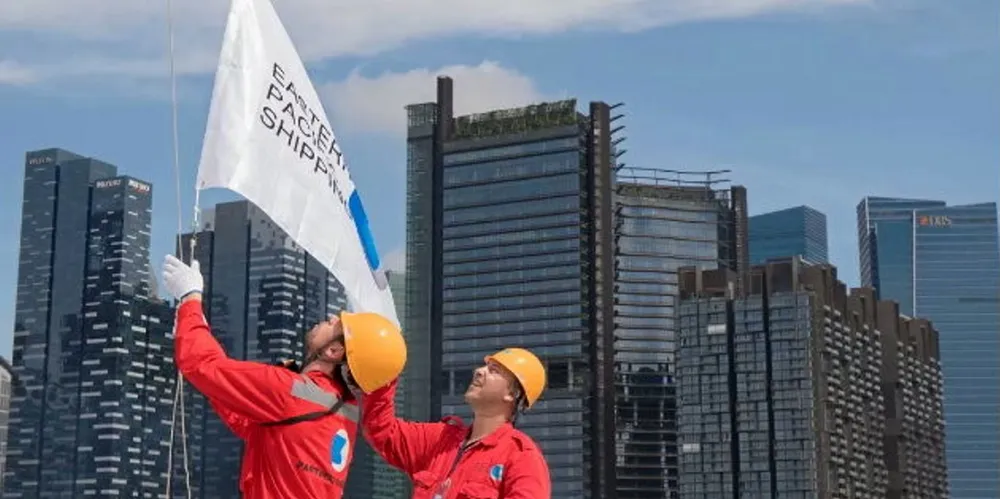 Eastern Pacific Shipping employees host a company flag in Singapore.