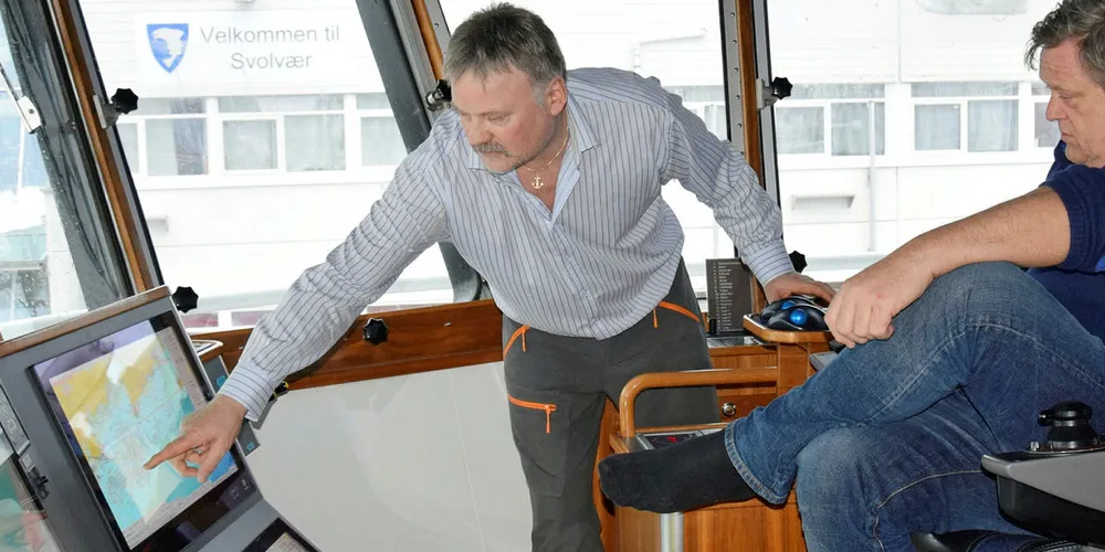 FORKLARER: Skipper Meløysund peker og forklarer for fiskeriminister Nesvik, som har fått låne skipperstolen for anledningen.