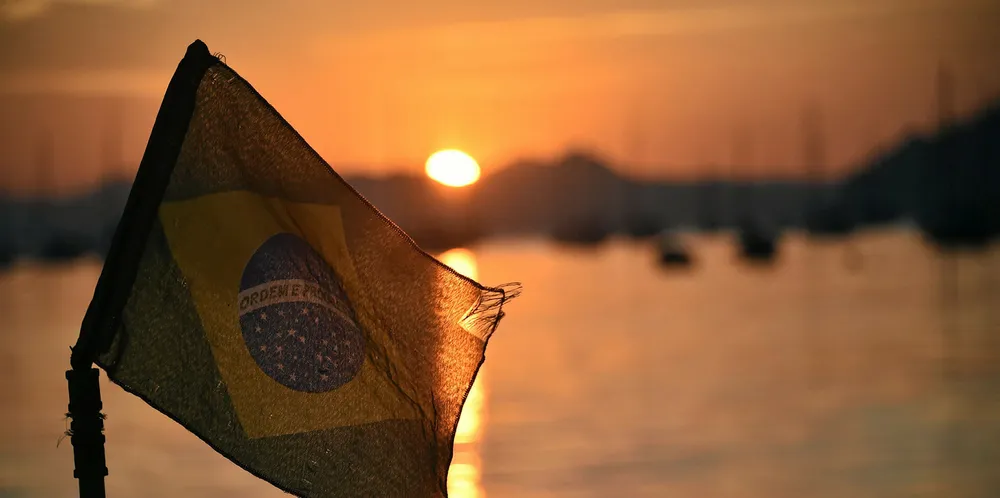 The Brazilian flag flies at sunrise on the Botafojo beach in Rio de Janeiro.