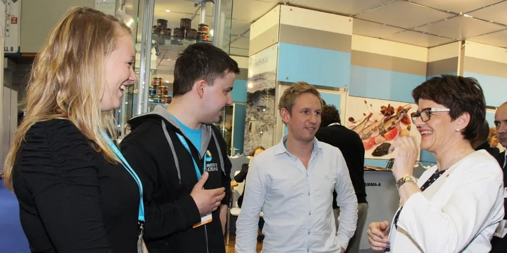 Studentene Torstein Mellingen, Rasmus Husby Larsen og Kristine Belt hilser på fiskeriminister Lisbeth Berg-Hansen.