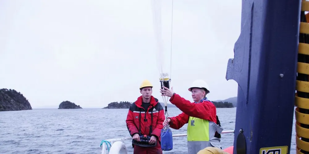 Maskinist Christian Brakstad og avdelingsingeniør Grethe Thorsheim er i ferd med å senke håven for å sikre vannprøver i Stangfjorden, en fjordarm av Stokksundet, nordvest av Stord. Foto: Torhild Måkestad Martinussen