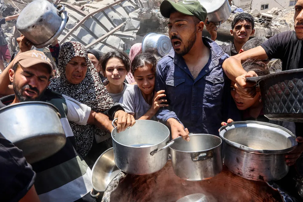 Palestinere i kø for å få et varmt måltid i Rimal utenfor Gaza by.