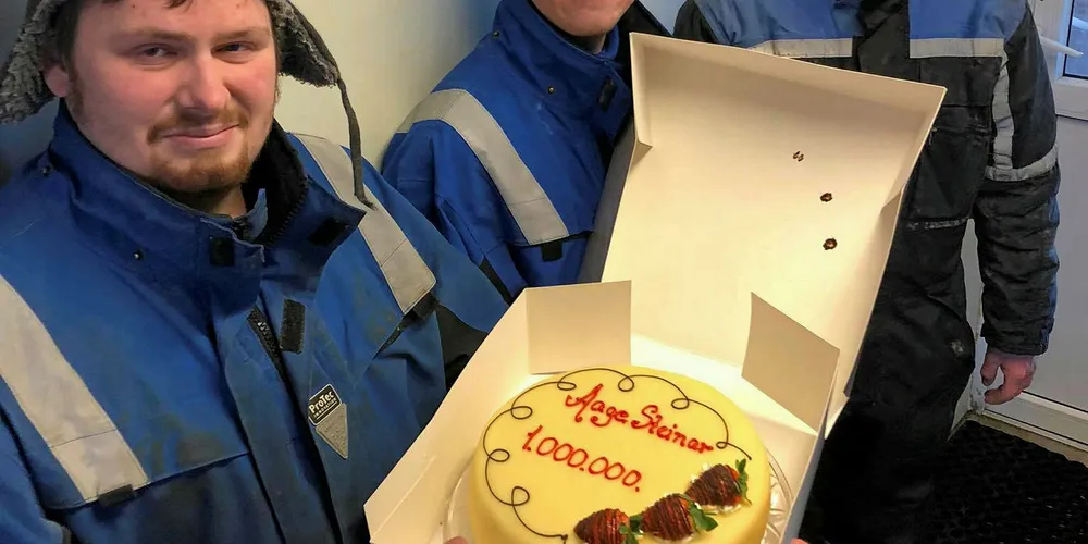 BELØNNET MED KAKE: Håvard Vikedal Pedersen, Vegard Vikedal Pedersen og Sander Karlsen på «Aage-Steinar» fikk kake hos AS Glea på Røst for å ha levert fangst for totalt en million kroner så langt i sesongen til fiskebruket. Foto: AS Glea/Facebook