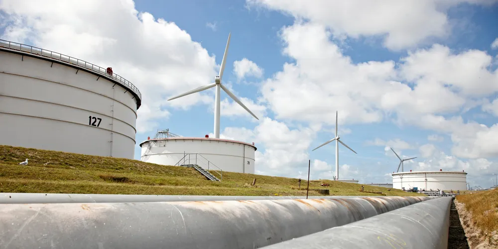 A view a the pipework running past storage tanks and wind turbines at BP's Rotterdam refinery in the Netherlands