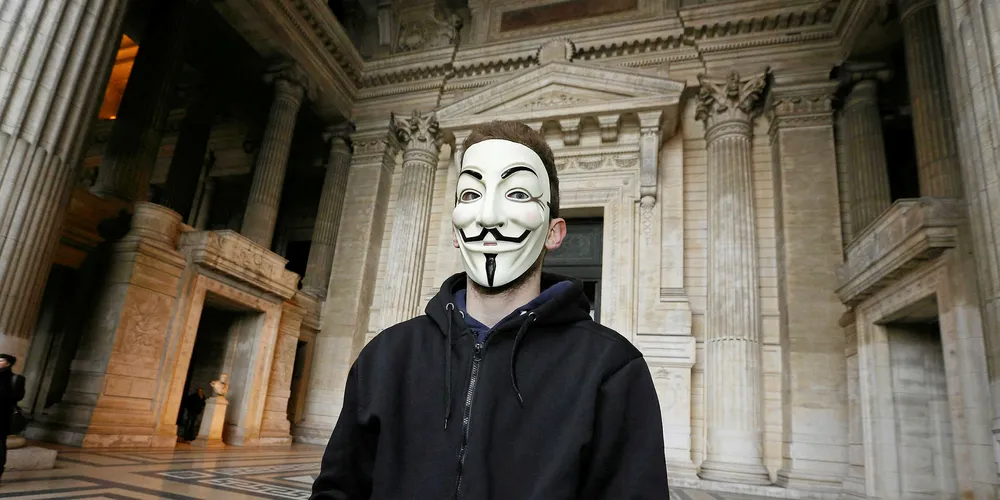 A member of the hackers collective Downsec Belgium, accused of cyber attacks on government sites, wears a Guy Fawkes mask ahead of the start of a trial in Brussels. Pic: NICOLAS MAETERLINCK/AFP/Getty Images
