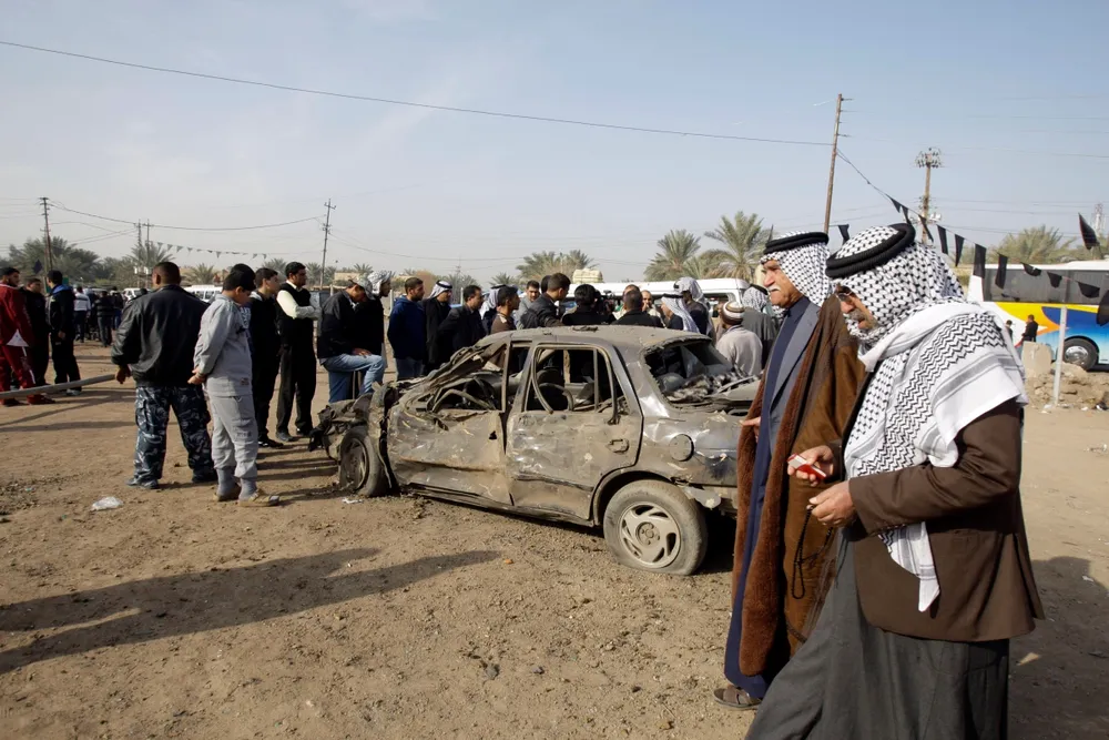 Security threat: police inspect the scene of a car bomb attack in mainly Sunni western Baghdad on 10 January