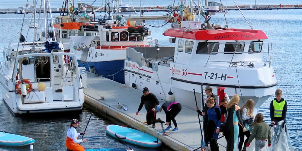 PÅ PLASS: Den lokale fiskeflåten i flaggsmykket utgave fikk vist seg fram under helgas «Skvulp»-arrangement i Harstad. I forgrunnen gjøres det klar for stående brettpadling, med yoga som ekstramoment.