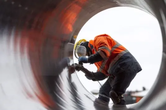 A worker inspects the BTC pipeline.