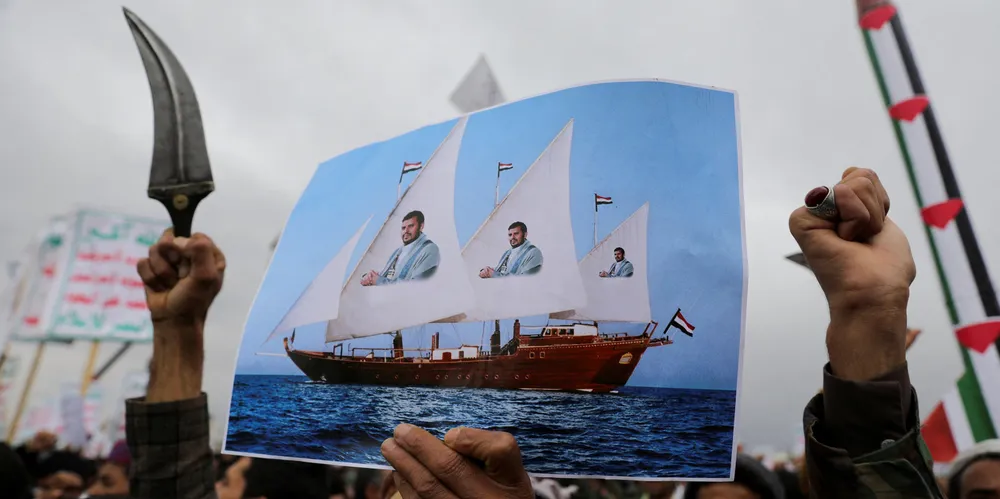 A protester holds a poster during a rally held by protesters, mainly Houthi supporters, to show support to Palestinians in the Gaza Strip in Sanaa, Yemen, on Friday. On the same day, the Houthis attacked an MSC ship in the Indian Ocean.