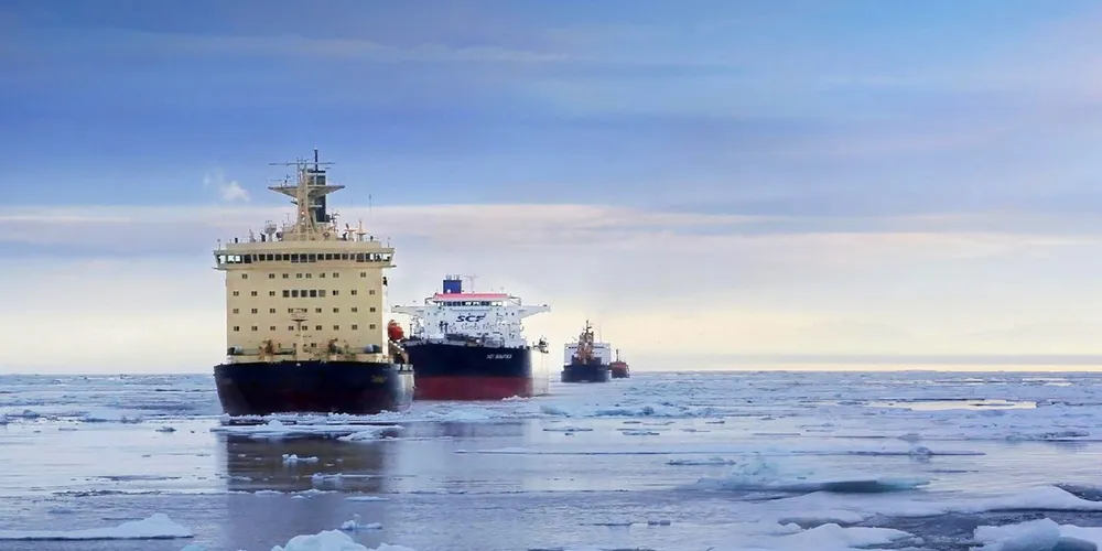 A convoy of ships sail through the Northern Sea Route north of Russia.