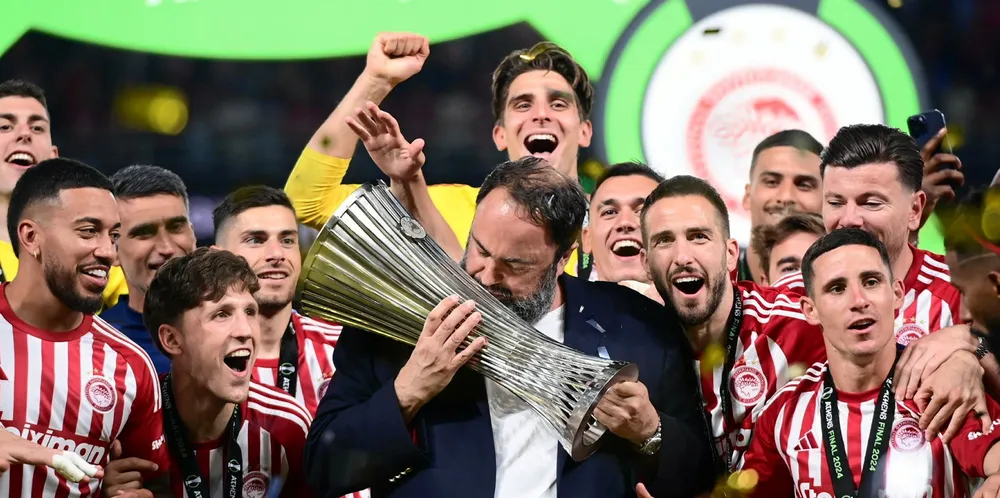 Shipowner Evangelos Marinakis lifts the UEFA Europa Conference League as chairman of winners Olympiacos.