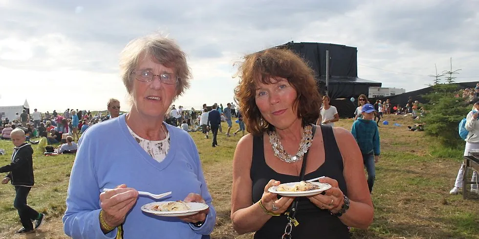 Edel Holthe og Gudrun Borttveit smaker på seibiff servert av Surofi under Sommerfesten på Giske. Foto: Torhild Måkestad