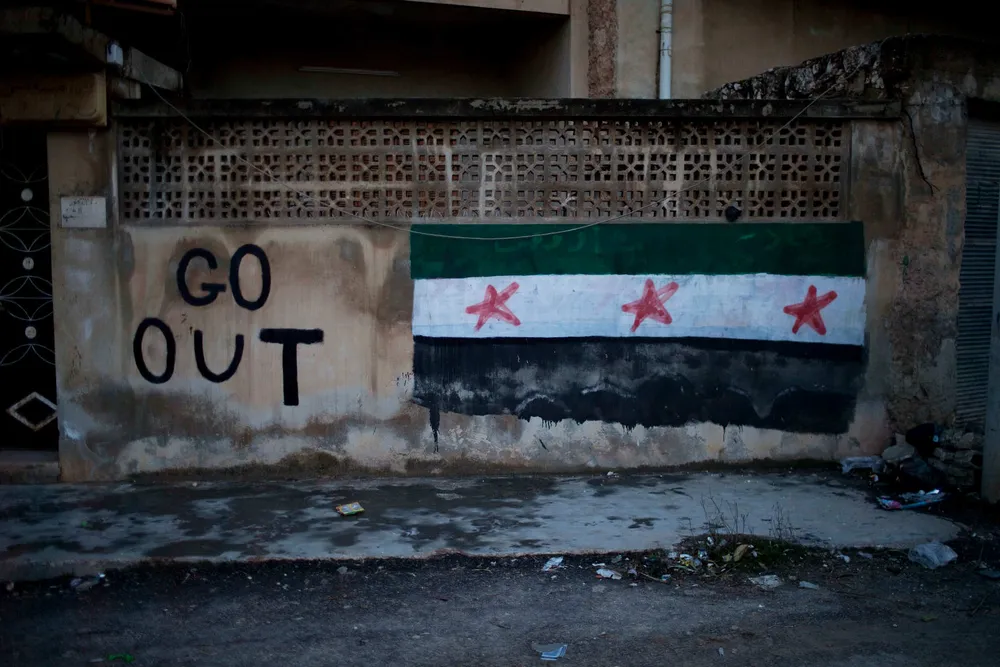 Cautionary: Graffiti of a Syrian revolutionary flag on the outskirts of Idlib, north Syria.