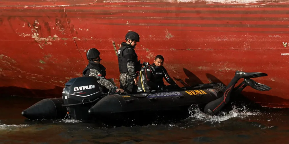 Members of Ecuador’s Special Mobile Anti-Narcotics Group inspect the underside of a freight ship at the Port of Guayaquil.
