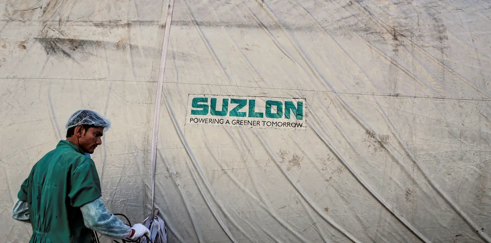The Suzlon Energy Ltd. logo is displayed on a wind turbine blade cover at the company's rotor blade manufacturing plant in Bhuj, India.