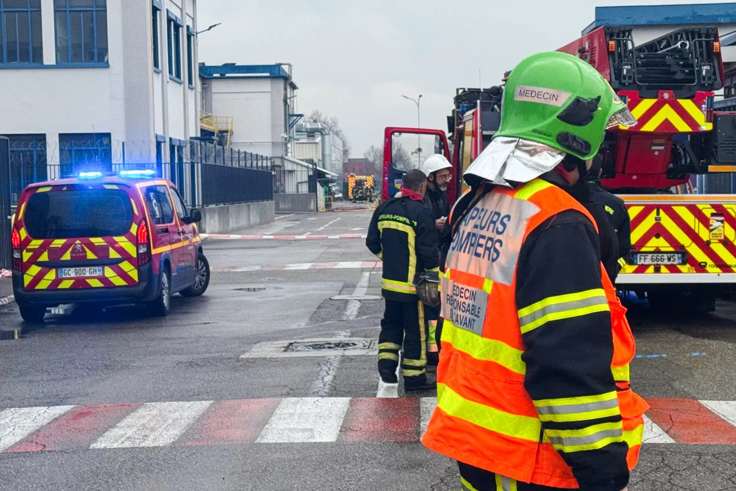 Firefighters stand next to fire trucks at the site of Elkem Silicones chemical plant, in Saint-Fons, central-eastern France, where an explosion took place