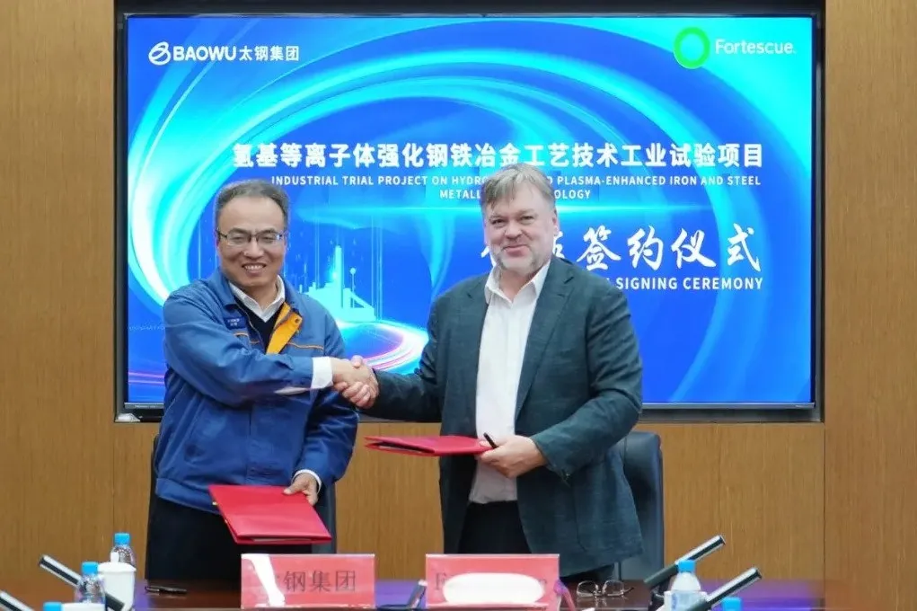 Nan Hai, a member of the Party Standing Committee of Taiyuan Group, and Andrew Hamilton, global technical director of Fortescue, shaking hands after signing the cooperation agreement.