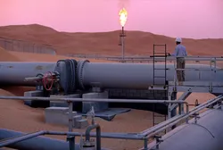 SHAYBAH, SAUDI ARABIA - MARCH 2003: A worker stands at a pipeline, watching a flare stack at the Saudi Aramco oil field complex facilities at Shaybah in the Rub' al Khali ("empty quarter") desert on March 2003 in Shaybah, Saudi Arabia. (Photo by Reza/Getty Images) . Saudi pipeline.